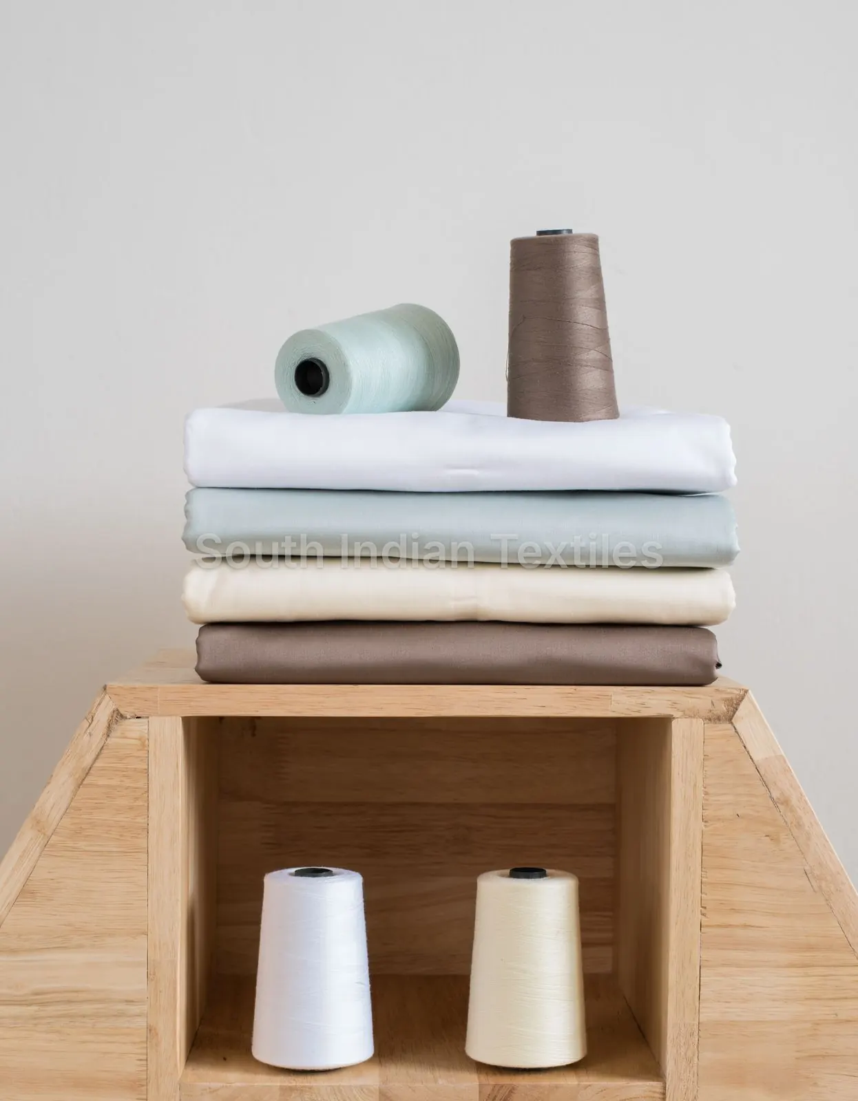 Folded cotton fabrics and thread cones in our fabric warehouse